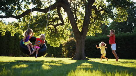 children playing on a tire swing in a sunny backyard