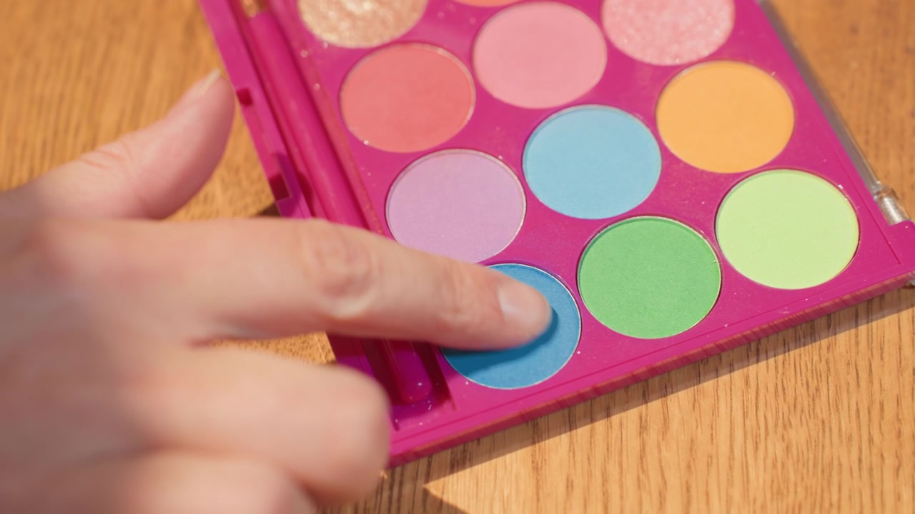 Finger Touching Blue Eyeshadow in a Vibrant Colorful Palette