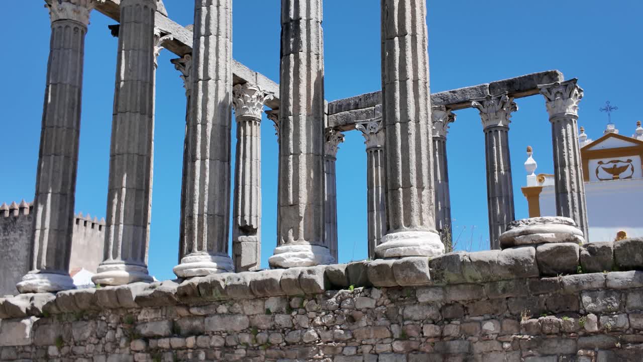 Ancient Roman Temple ruins in Évora, Portugal with tall columns and clear blue sky