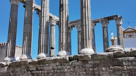 ancient roman temple ruins in évora, portugal with tall columns and clear blue sky