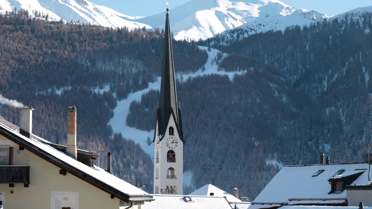 겨울 동안 스위스 주오즈의 전통적인 스위스 마을에 있는 교회, 산, 주택의 전망