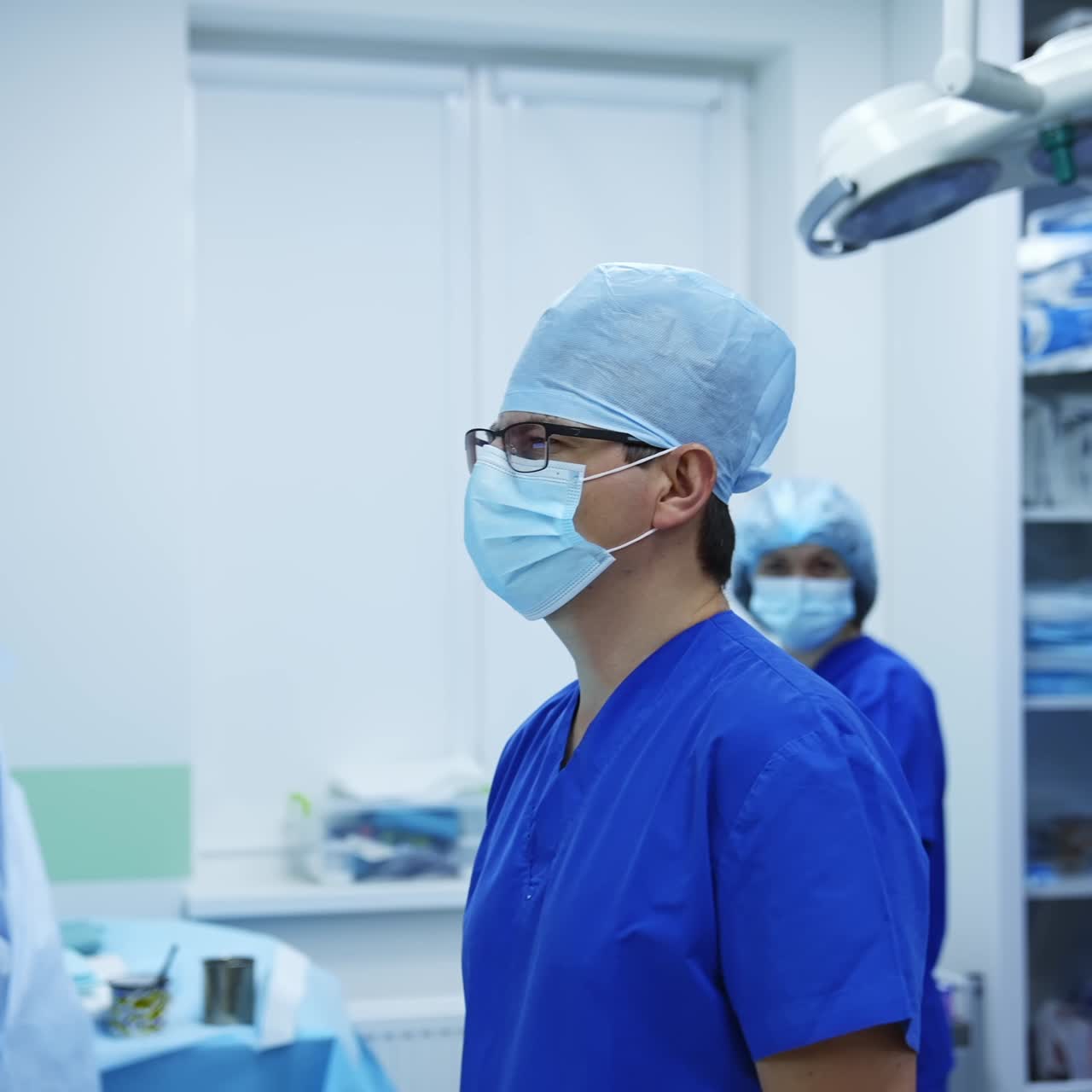 Male doctor in modern clinic. Professional surgeon in medical uniform observing patient's x ray photograph before the operation