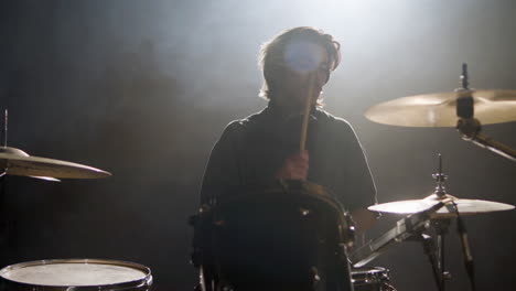 young male drummer playing drums at music studio