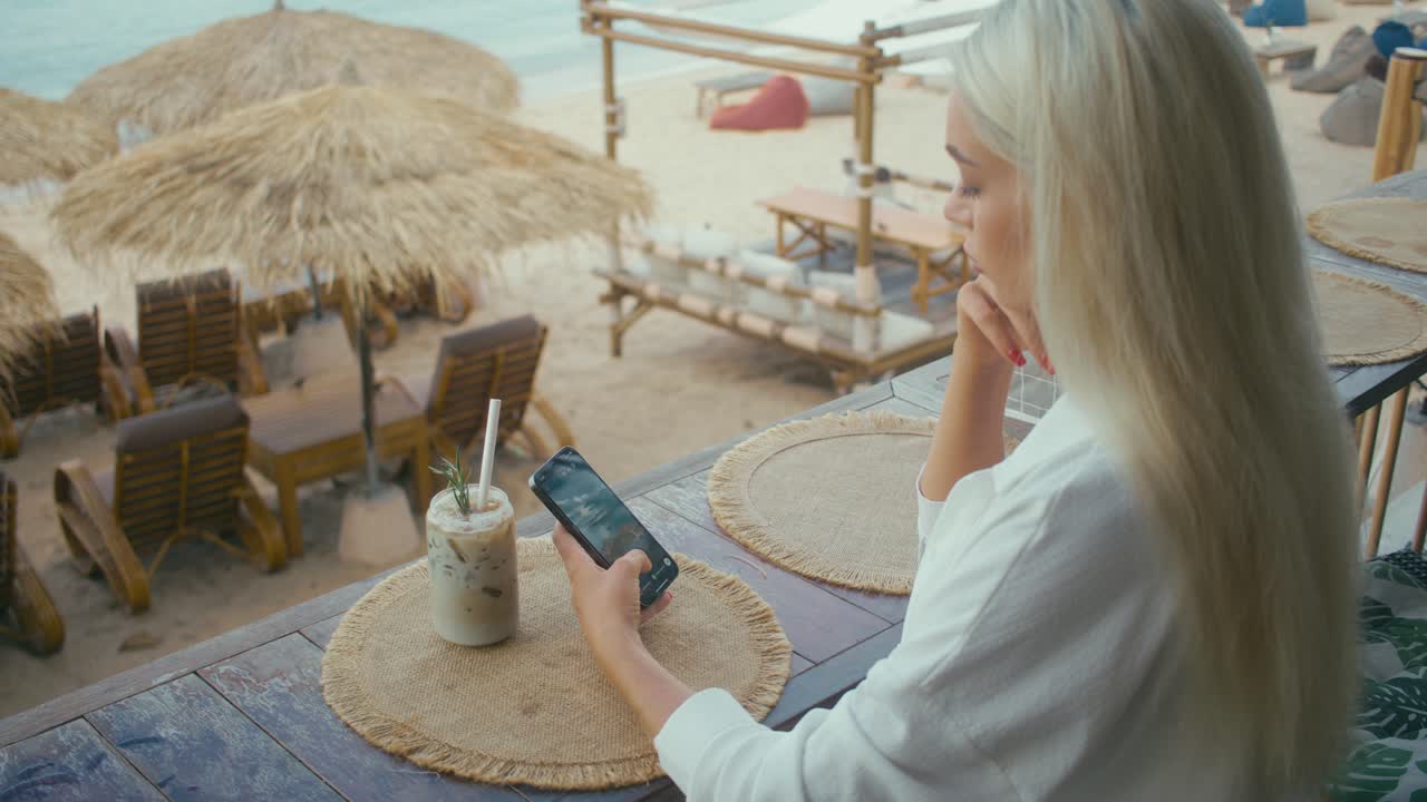 Woman enjoying coffee at a beach cafe