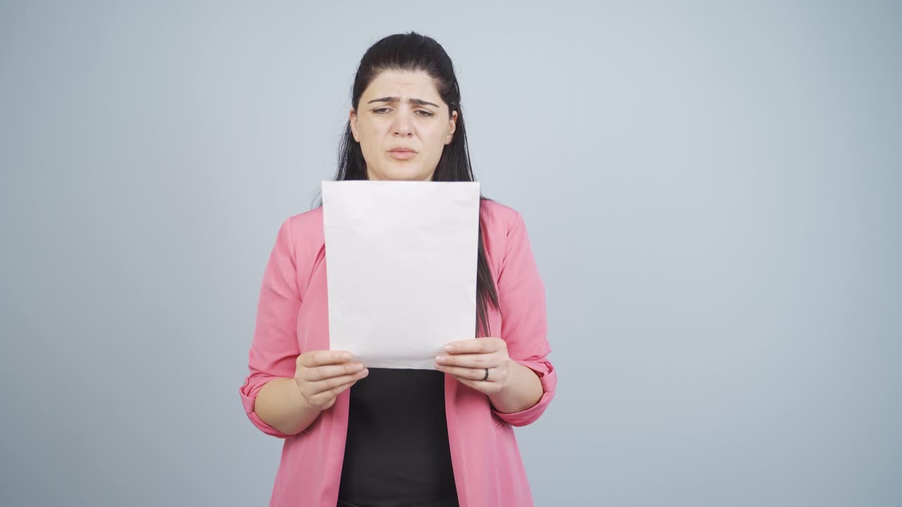 Business woman examines paperwork and gets upset.