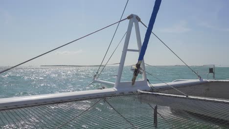 Catamaran-in-Caribbean,-mast-and-safety-net,-sailing-forward