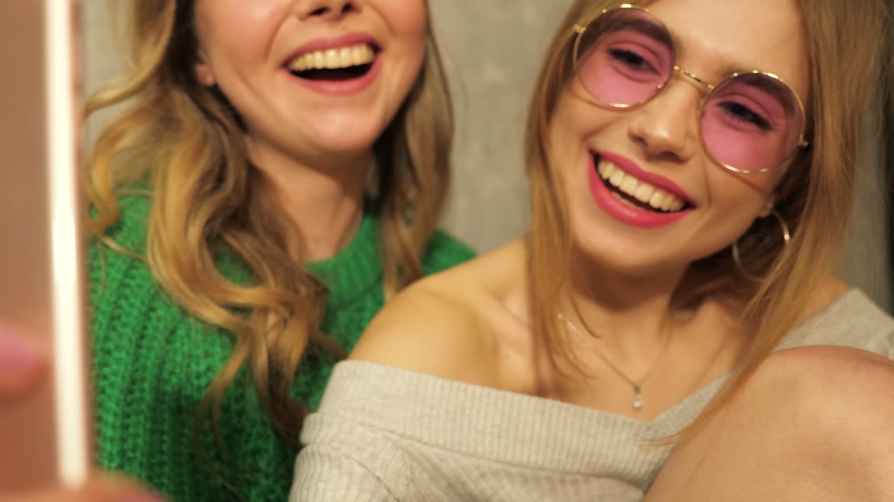 두 명의 행복한 젊은 여성들이 셀피를 찍고 있습니다.