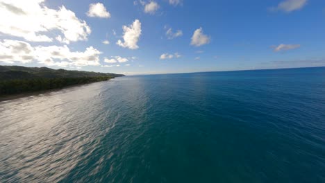 el agua del océano azul profundo y limpio refleja el cielo con nubes a lo largo de la costa tropical de la playa de coson.