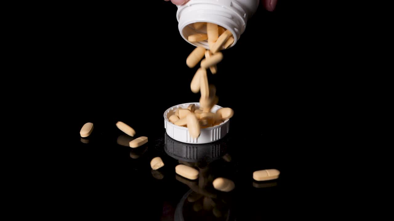 recipiente de medicamentos recetados vertiendo pastillas en una tapa, cámara lenta