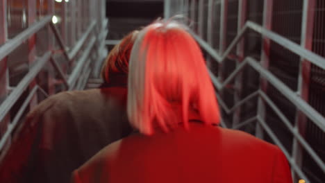 couple walking through pedestrian bridge in night