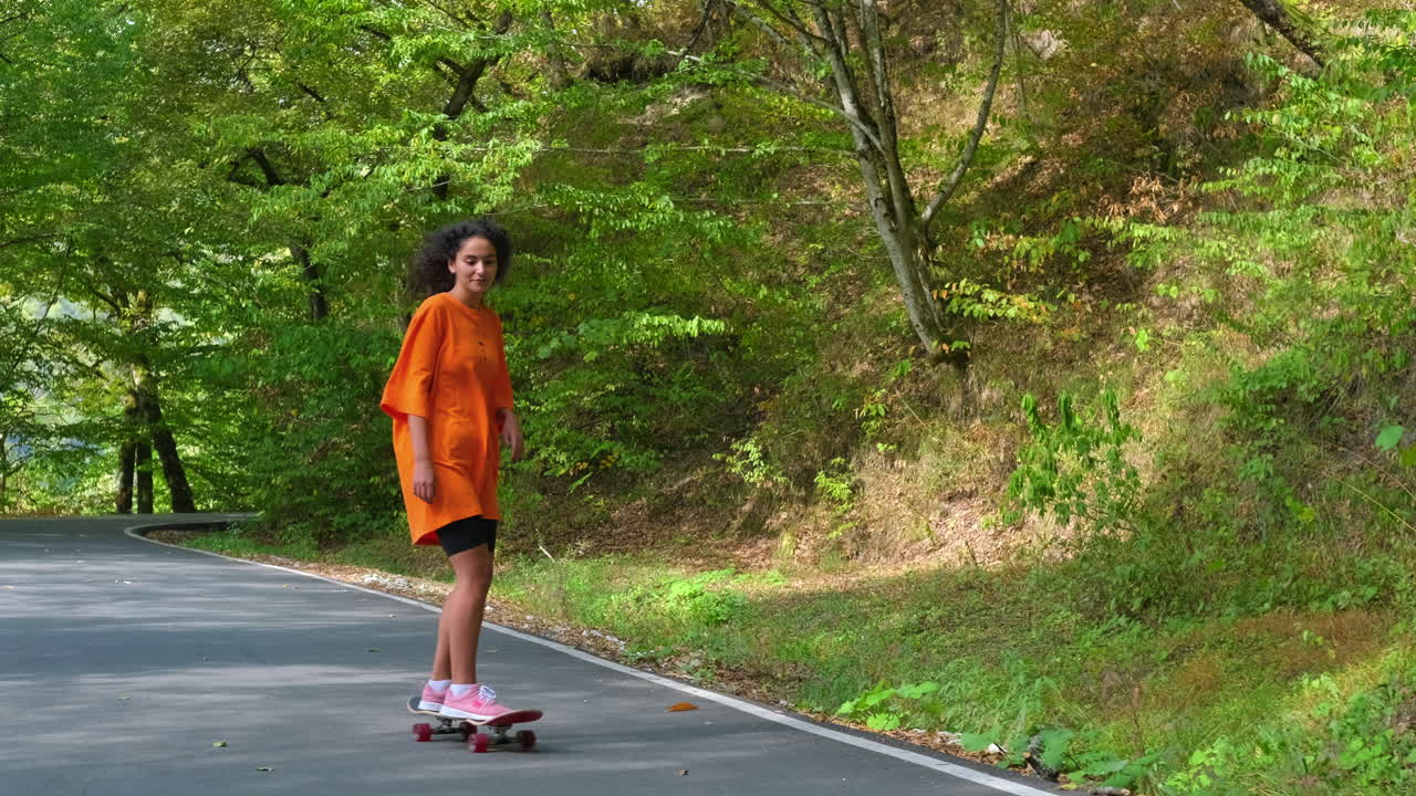Donna in skateboard nel bosco