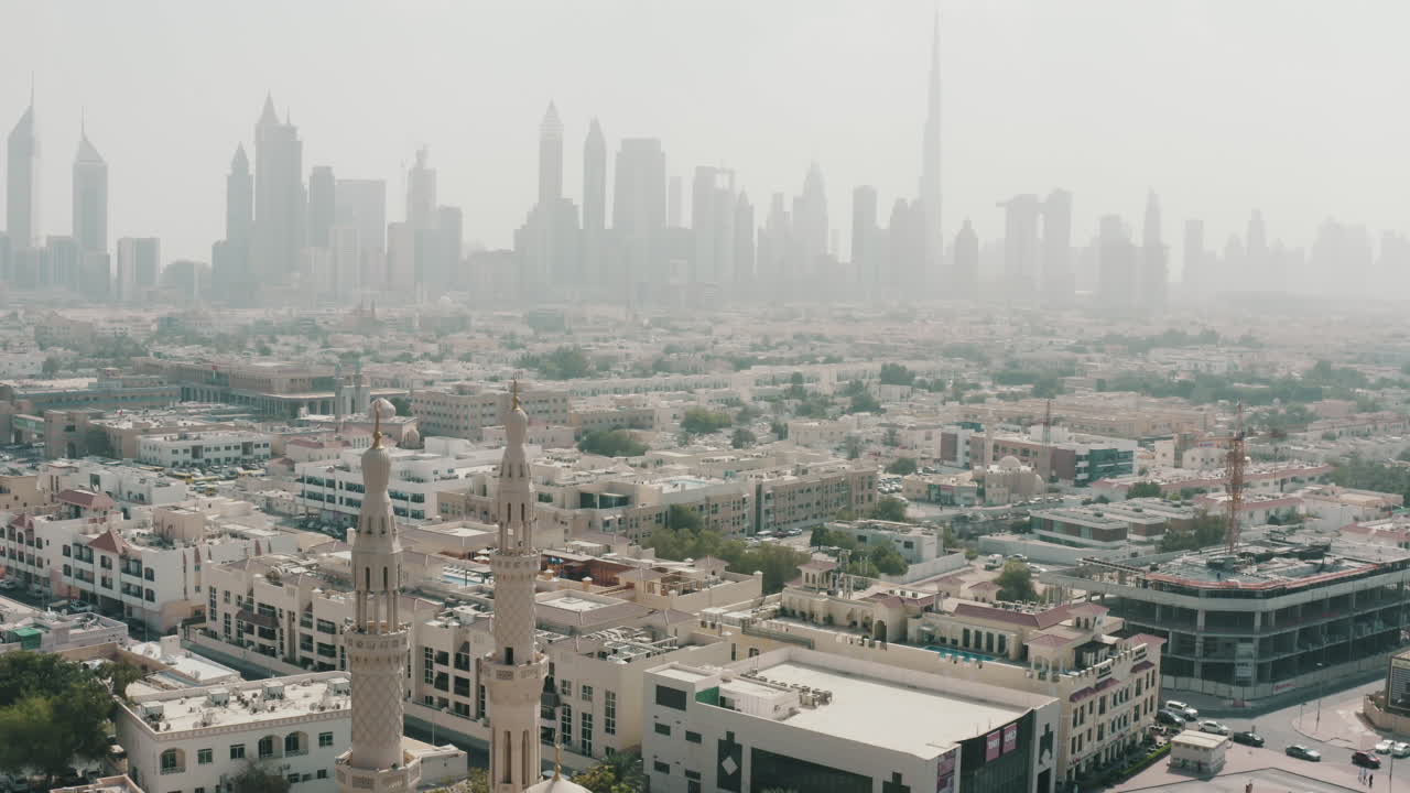 Dubai cityscape around Jumeirah Mosque with Skyscrapers silhouette background, aerial dolly in