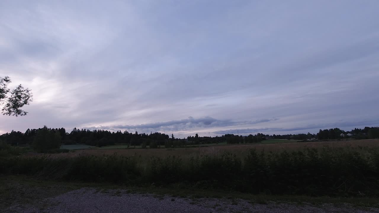 Timelapse di un tramonto in Lapponia con campo, foresta e nuvole.