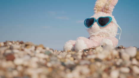 Conejo-De-Peluche-Con-Gafas-De-Sol-Tomando-El-Sol-En-La-Playa-Video-4k