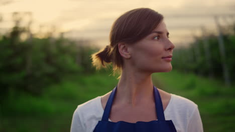 Beautiful-woman-farmer-walking-garden-looking-harvest-in-sunset-plantation-house