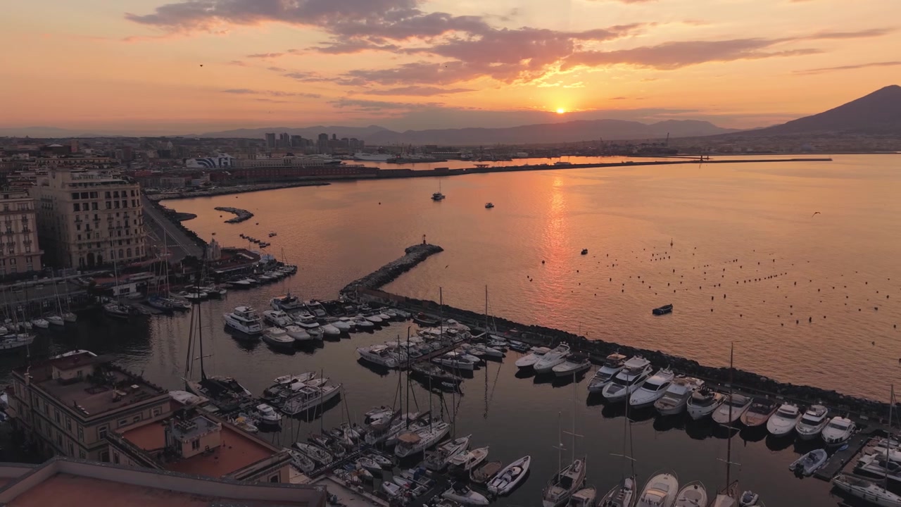 Spettacolare alba ripresa con drone su Castel dell'Ovo, Napoli, Italia, porto e Vesuvio