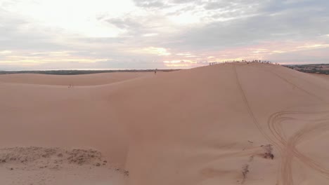 cinematic aerial drone reveal shot of beautiful golden sunrise over vietnamese sand dunes in remote southern region