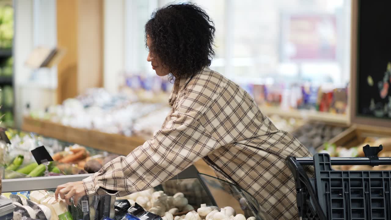 African American stylish woman choosing packed vegetables in supermarket
