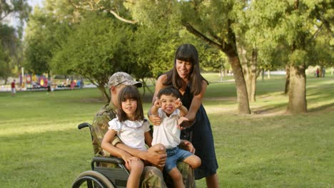 Happy-mom-taking-selfie-with-two-kids-and-disabled-dad