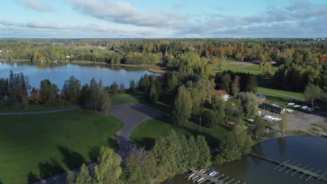 Flyover tidy docks of rowboats in lake marina in Finland forest