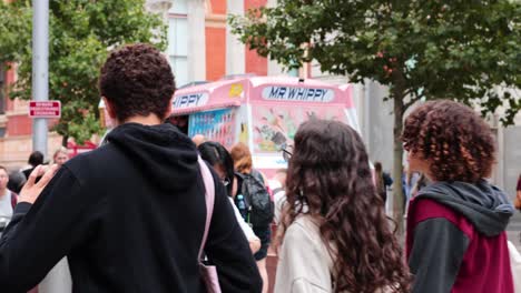 la gente se reúne alrededor del camión de helados en londres.