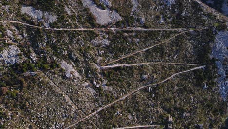 serpentine ground road on boundless steep mountain slope with red roof houses in national park lovcen at spring sunlight bird eye view