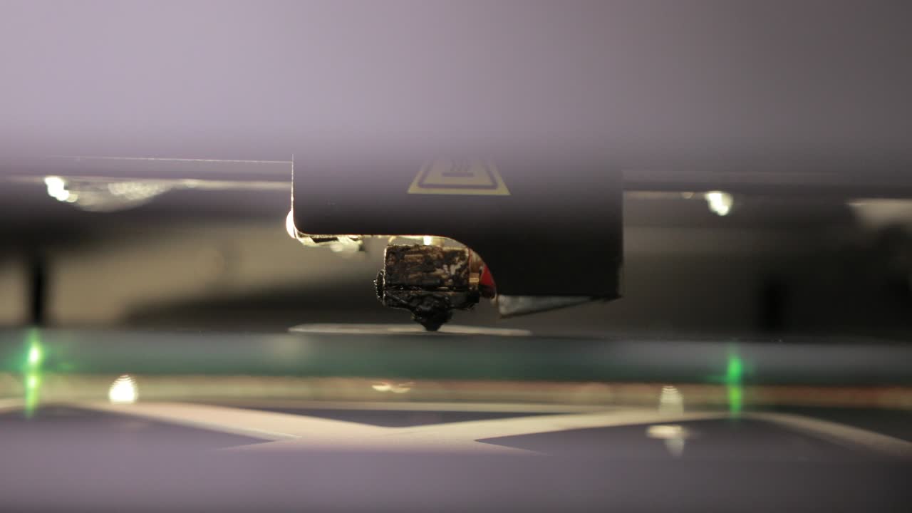 3D technology close up of the printer head printing a plastic part product.