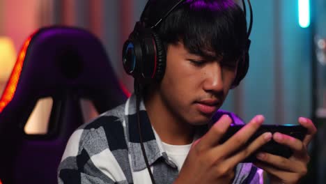 close up of asian teen boy gamer lose while playing video game on smartphone