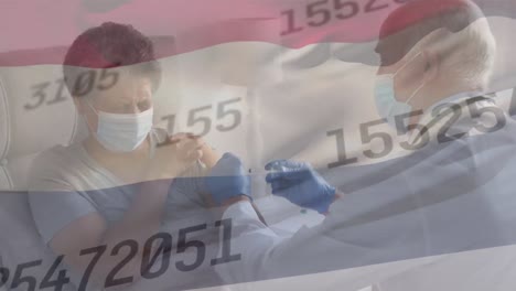 Animation-of-numbers-and-netherlands-flag-over-diverse-male-doctor-vaccinating-senior-woman