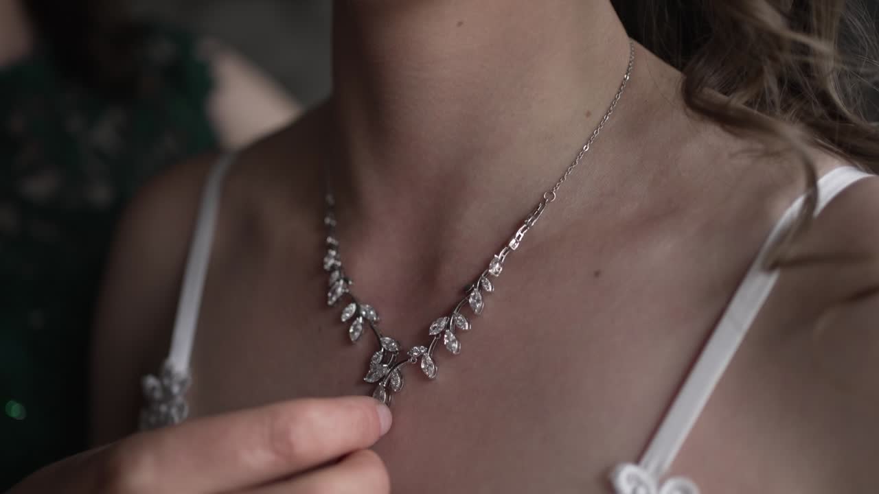 Close up of a delicate bridal necklace being adjusted