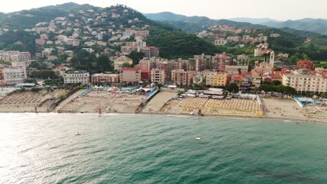 colorful buildings along the ligurian coast with a bustling beach and clear blue sea