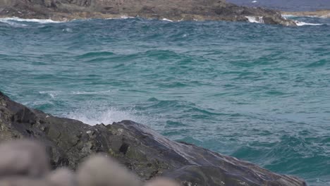 agitated sea crashing into rocks in slow motion