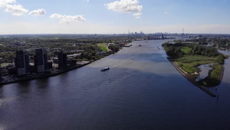 aerial view of boat cruising at nieuwe maas river near kinderdijk in netherlands