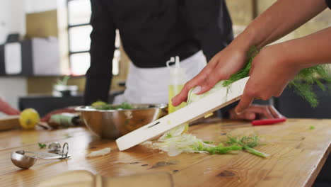 cocinera caucásica que enseña a un grupo diverso usando máscaras faciales