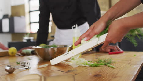 caucasian female chef teaching diverse group wearing face masks