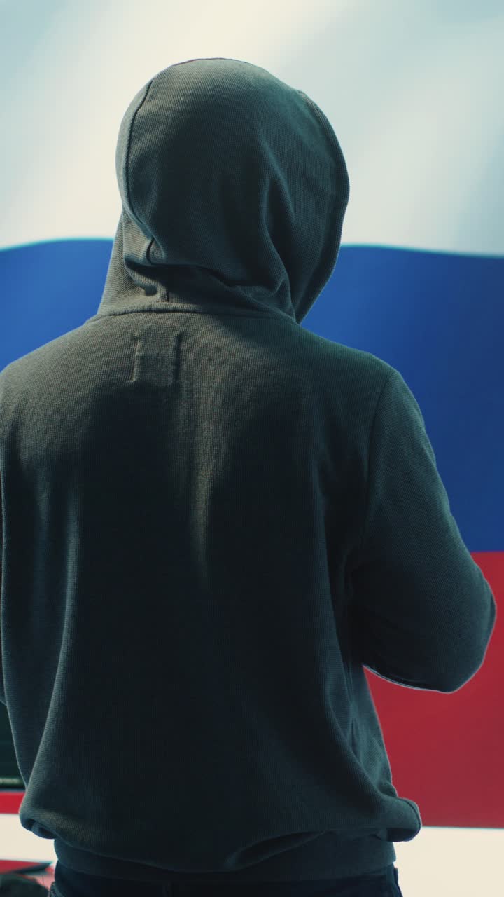 Hacker anonimo che programma con bandiera russa sullo sfondo