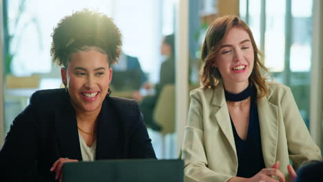 two businesswomen have a conversation at a meeting in an office