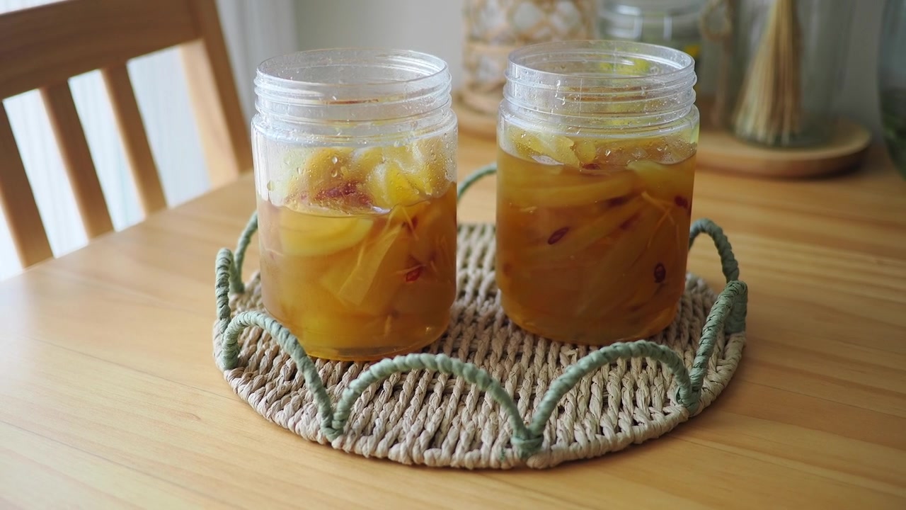 Two Jars of Homemade Preserved Fruit on a Wooden Table