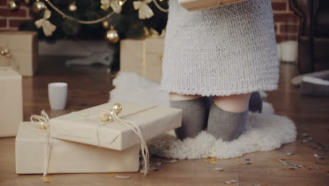 woman opening gift boxes. young woman with presents in new year interior in the living room