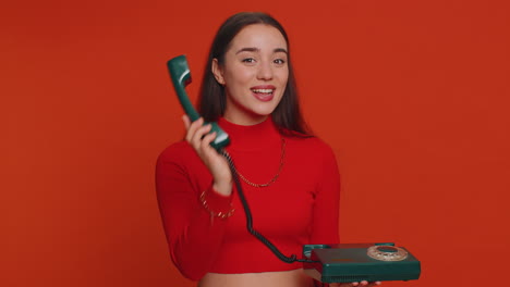 Young-woman-talking-on-wired-vintage-old-fashioned-retro-telephone-of-80s,-says-hey-you-call-me-back