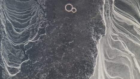 three people ice skating on a frozen lake that has a pattern that looks like from another planet