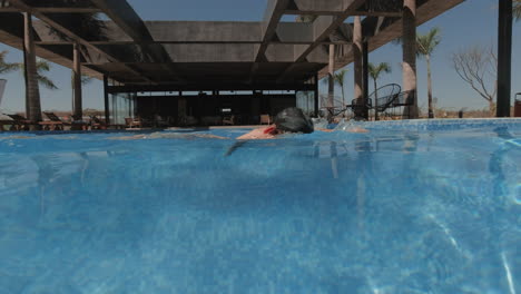 underwater traveling of beautiful young woman dives and swims, camera comes out abruptly of the water slow motion