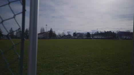 cars in the distance of empty sports complex field in 4k