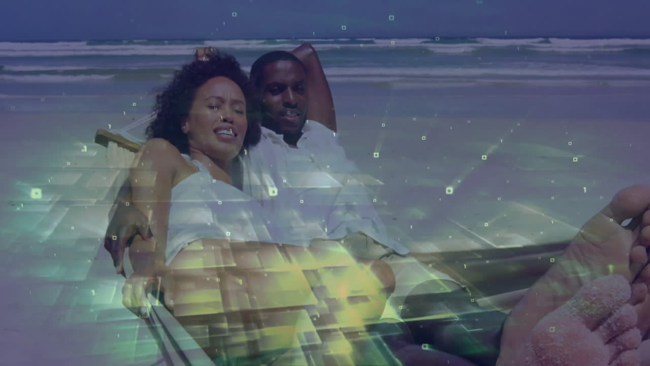 Couple relaxing on beach with digital data processing animation overlay