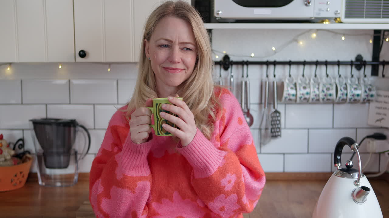 mujer bebiendo café en la cocina