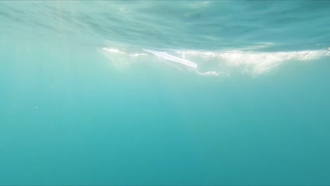 Underwater-point-of-view-swimming-fast-under-sweeping-rowing-boat-paddles