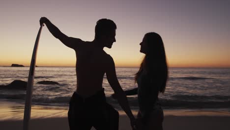 una joven pareja de adultos relajándose en una playa al atardecer