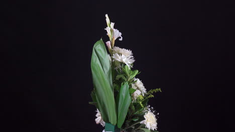 Pequeño-Arreglo-Floral-Tropical-Funerario-Girando-En-Fondo-Negro