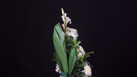 pequeño arreglo floral tropical funerario girando en fondo negro