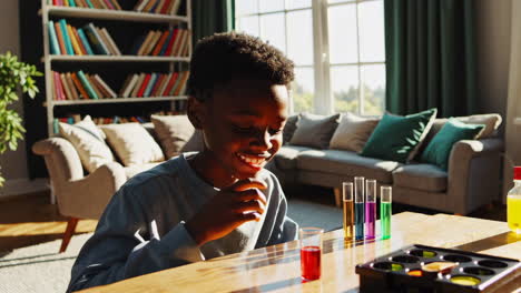 young boy engaged in a colorful science experiment at home